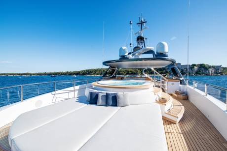 Relax on the spacious deck of this luxurious yacht, complete with a hot tub and ample sunbathing space.