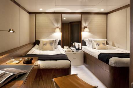 Luxurious twin beds with plush bedding and decorative pillows create a serene retreat on this elegant yacht.