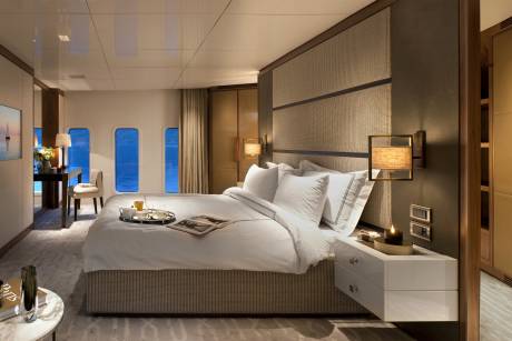 Luxurious yacht stateroom offers serene ocean views and a plush bed for ultimate relaxation.