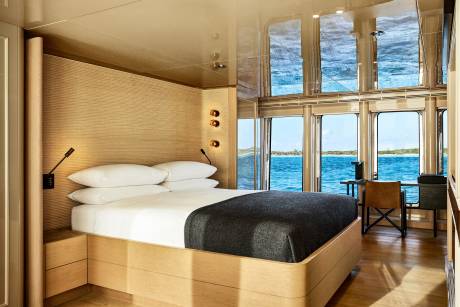 Luxurious cabin interiors offer stunning ocean views through expansive windows, creating a serene and sophisticated retreat.