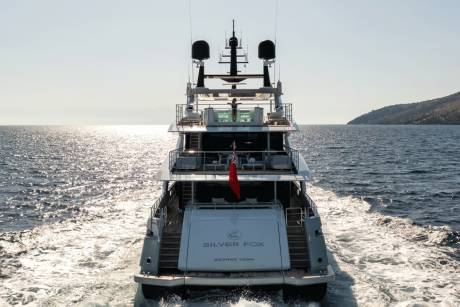 A luxurious yacht named Silver Fox cruises through sparkling blue waters under a clear sky.