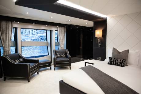 Luxurious yacht interiors feature plush seating and a comfortable bed with a view of the marina.