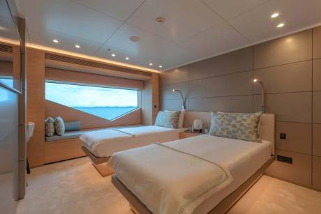 Twin beds with ocean views offer a serene retreat aboard this luxurious yacht.