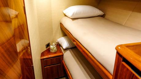 Luxurious bunk beds offer a cozy retreat within the richly paneled interior of this elegant yacht.