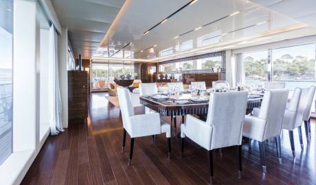 Elegant dining chairs surround a set table in this luxurious yacht's spacious interior.