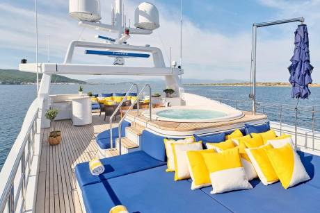 Relax on the spacious deck of this luxury yacht, complete with a bubbling hot tub and plush seating.