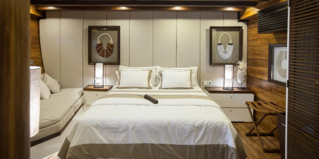 A luxurious bedroom features a plush bed, decorative artwork, and warm wooden accents for a serene retreat.