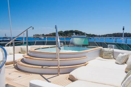 Relax in the luxurious jacuzzi with a cascading waterfall on this stunning yacht deck.
