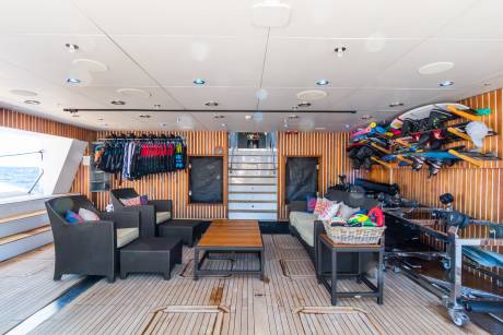 This yacht's deck offers a comfortable lounge area with water sports equipment readily available.