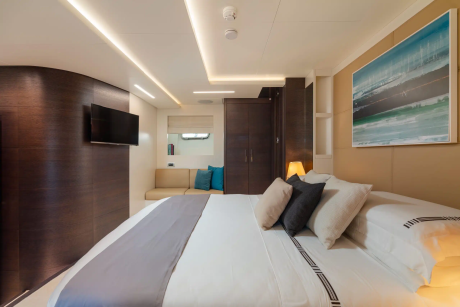 A modern and cozy hotel room with a large bed, a television, and a colorful abstract painting on the wall, creating a warm and inviting atmosphere.