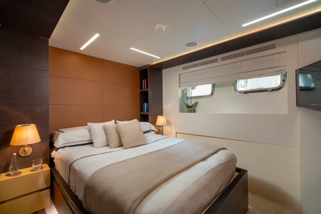 A cozy and modern bedroom with a large bed, bedside tables, and a window providing natural light.