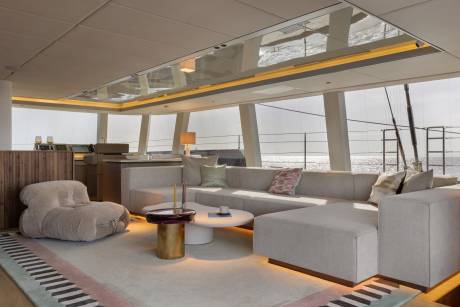 Relax in this chic yacht lounge with plush seating and stunning ocean views through expansive windows.