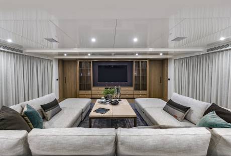 Plush sofas and a sleek entertainment center create a luxurious living space aboard this modern yacht.