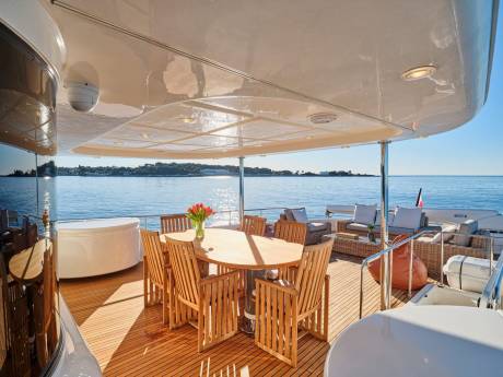 Enjoy al fresco dining and relaxation on the spacious deck of this luxurious yacht overlooking the azure sea.