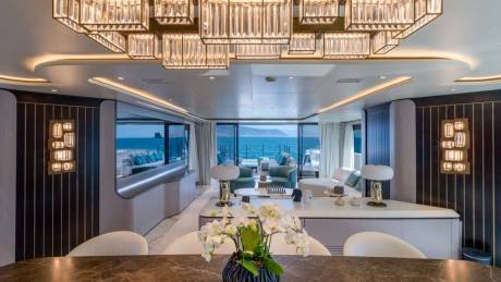 A luxurious yacht interior features a stunning crystal chandelier and panoramic ocean views.