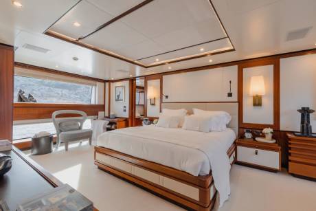 Luxurious yacht bedroom offers a serene retreat with plush white bedding and stunning ocean views.