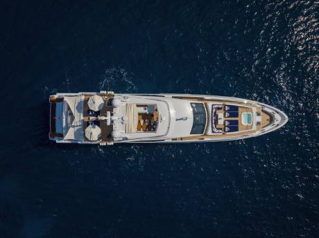 A luxurious yacht glides through the deep blue sea, offering a serene escape with its elegant decks and inviting jacuzzi.