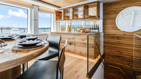 Dine in style aboard this luxurious yacht, where a beautifully set table offers stunning ocean views and a well-stocked bar awaits.
