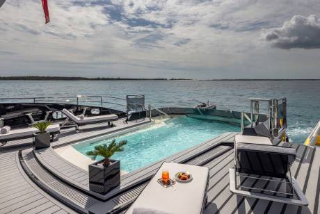 Relax by the inviting pool on this luxurious yacht, surrounded by the serene turquoise waters of the ocean.