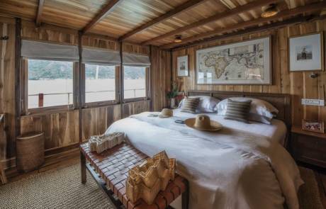 Luxurious wooden interiors and a large world map create a cozy and adventurous atmosphere in this unique bedroom.