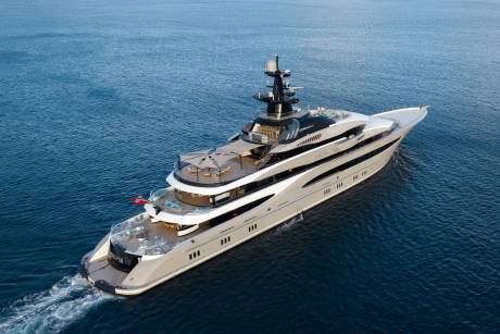 A luxurious superyacht glides through the deep blue ocean, its sleek design cutting through the waves.