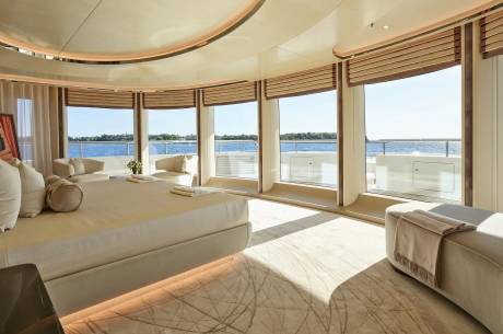 Luxurious yacht bedroom offers panoramic ocean views through expansive windows and a curved ceiling.