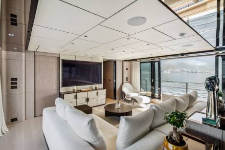 Luxurious yacht interiors offer stunning waterfront views through expansive glass doors.