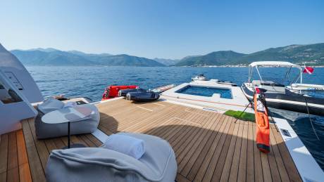 Relax on the spacious deck of a luxury yacht, surrounded by stunning mountain scenery and crystal-clear waters.