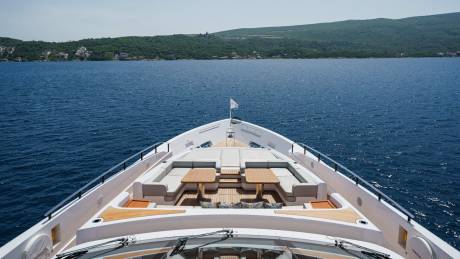 Luxurious yacht seating and tables offer a prime spot for enjoying the sun-drenched Mediterranean waters.