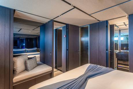 Luxurious dark wood paneling and plush seating create an opulent retreat within this modern yacht cabin.