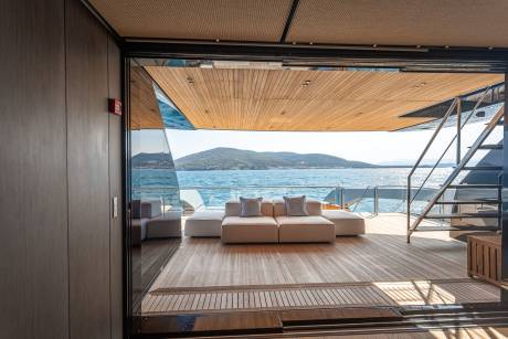 Relax on the plush deck seating while enjoying the stunning coastal views from this luxurious yacht.