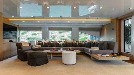 This luxurious yacht salon offers a serene escape with plush seating and stunning views of the rocky coastline.