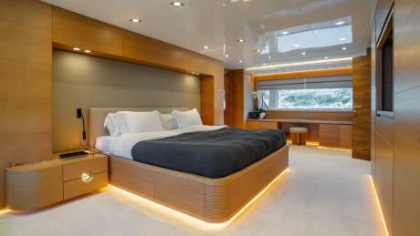 Luxurious yacht bedroom features warm wood accents, a plush bed, and ambient lighting for ultimate relaxation.