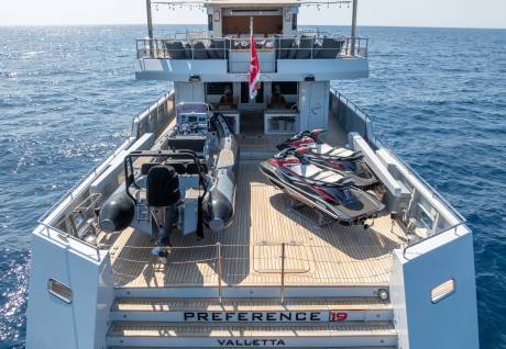 Two jet skis and a rigid inflatable boat are ready for adventure on the deck of the yacht Preference 19.
