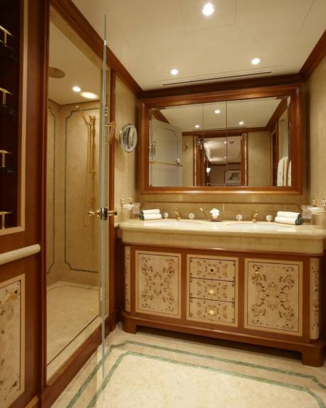 Luxurious marble and intricate wood inlay create an opulent atmosphere in this master bathroom.