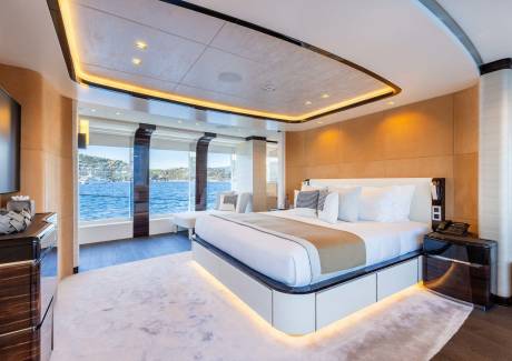 Luxurious yacht cabin offers stunning ocean views and plush comfort with ambient lighting.