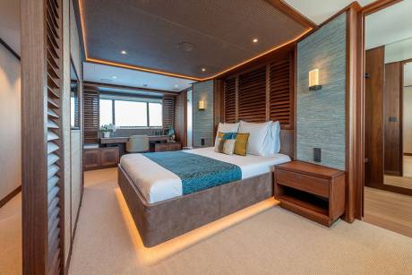 Luxurious wood paneling and soft lighting create a serene ambiance in this elegant yacht stateroom.