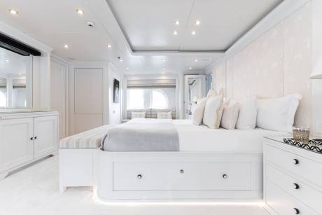 Luxurious white bedding and elegant furnishings create a serene master suite on this opulent yacht.