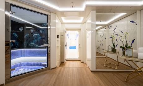 Step into a serene aquatic-themed spa area with a glass-enclosed pool and elegant mirrored walls.
