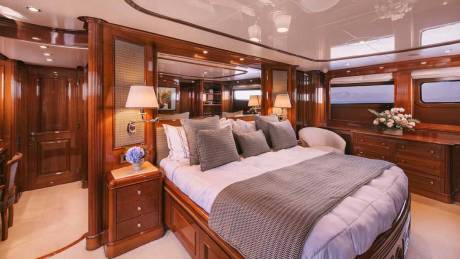 Luxurious wood finishes and plush bedding create an opulent master suite aboard this elegant yacht.