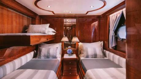 Luxurious wood paneling and plush bedding create a serene sleeping cabin aboard this elegant yacht.