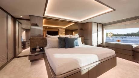 Luxurious yacht cabin offers a serene retreat with a king-sized bed and stunning waterfront views.