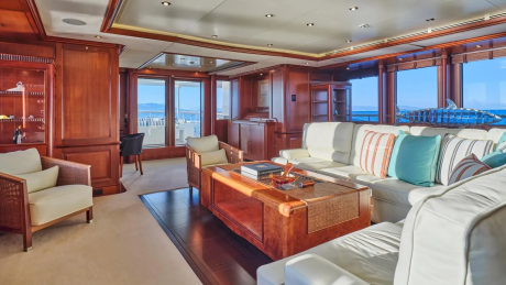 Luxurious yacht interiors offer a serene escape with plush seating and stunning ocean views through large windows.