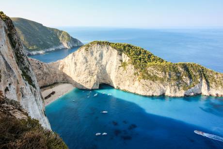 Navagio Beach, a stunning shipwreck cove on Zakynthos Island, Greece, beckons with its turquoise waters and dramatic white cliffs.