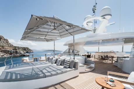 Luxurious yacht decks offer ample space for sunbathing, relaxing in the hot tub, and enjoying drinks at the bar with a stunning coastal backdrop.