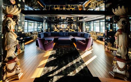 A lavishly decorated and ornate interior space with plush seating, intricate lighting fixtures, and a patterned floor, creating an opulent and inviting atmosphere.