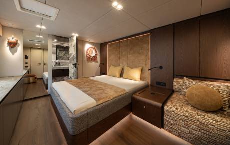 A luxurious bedroom with a plush bed in the foreground and a modern bathroom visible in the background.