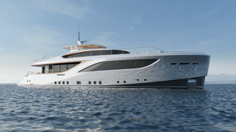 A sleek, modern white yacht floats on rippling blue water against a clear sky and distant mountains.