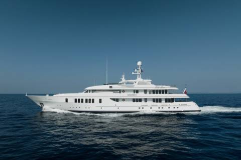 The luxurious yacht Samadhi glides through the deep blue sea under a clear sky.