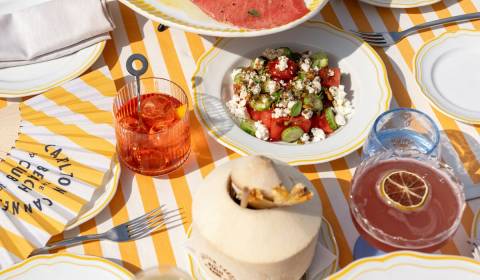 A refreshing spread of watermelon salad and cocktails awaits on a sunny table at the Carlton Beach Club in Cannes.
